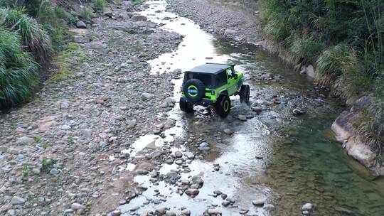 越野车跋山涉水穿越河道行驶在溪流石头水坑