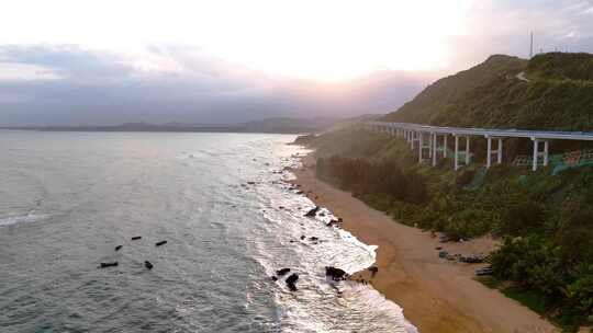 航拍大海落日天空海边的沿山公路三亚海边