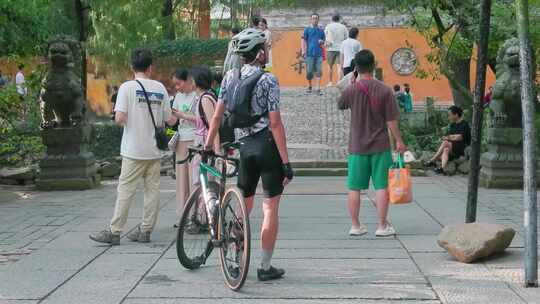 景区内骑行者与游客热闹互动的场景