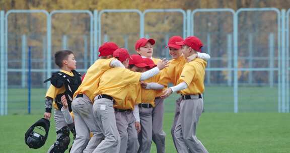 学校里的棒球一队穿着黄色制服的男孩棒球运动员得到拥抱和欢庆