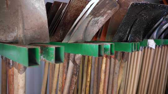 挂架上的各式旧铲子工具