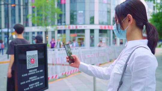 戴口罩的青年女人用手机扫健康码视频素材模板下载