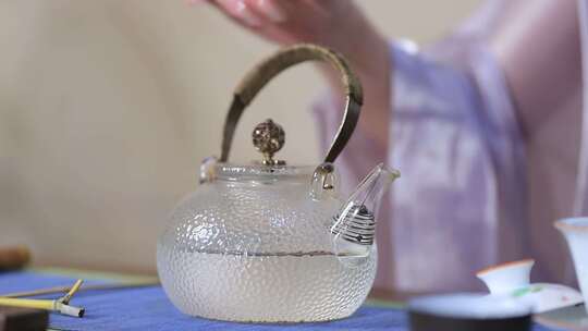 泡茶步骤：拿起装满开水的玻璃水壶