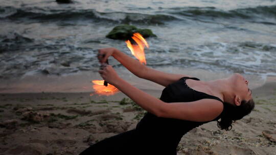 在海边的与火共舞的女性
