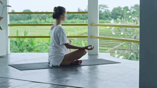 亚洲女生坐在阳台练瑜伽打坐视频素材模板下载