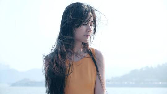 女孩在海边吹风，发丝飞舞