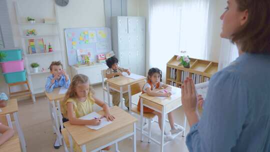 可爱的学生在小学教室里和老师一起学习。