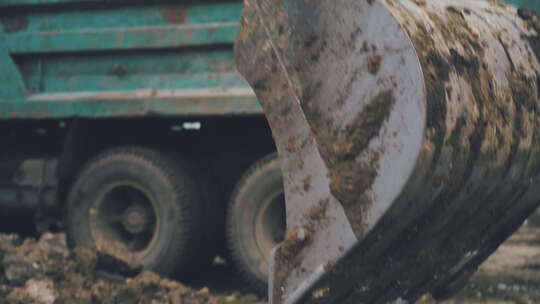 在农村修路时，挖掘机臂舀起一桶土和石头。视频素材模板下载