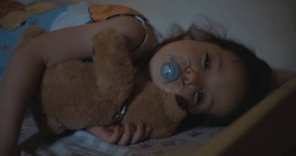 女孩在床上抱玩偶
