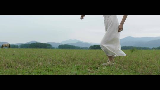 白色连衣裙女子在草原上跳舞舞步特写视频素材模板下载