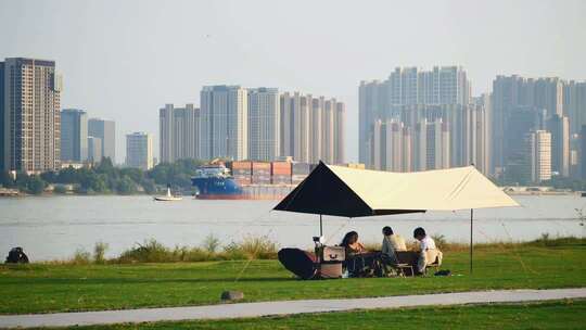 南京长江边滨江公园草地游客户外露营场景