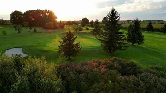 美丽的鸟瞰高尔夫球场绿色和日落在大自然
