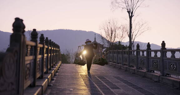 清晨从桥上挑着菜经过的农民