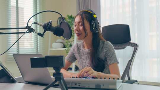 亚洲有吸引力的音频DJ女人对着麦克风说话广播。