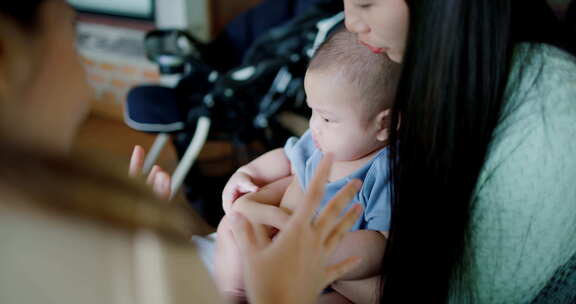 两个年轻的亚洲女人在咖啡馆里开心地和一个