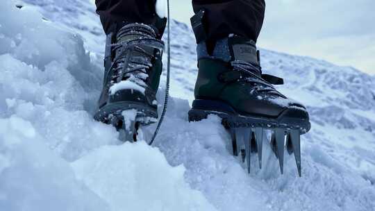 户外雪地中带冰爪的登山靴特写