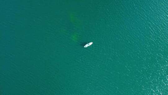 从漂浮在海洋上的船上的人的移动无人机看