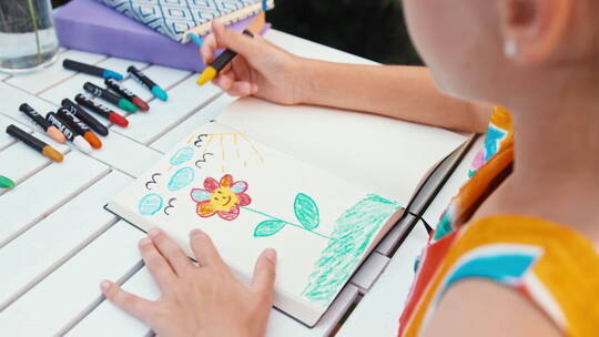 女孩用蜡笔在本子上画画视频素材模板下载