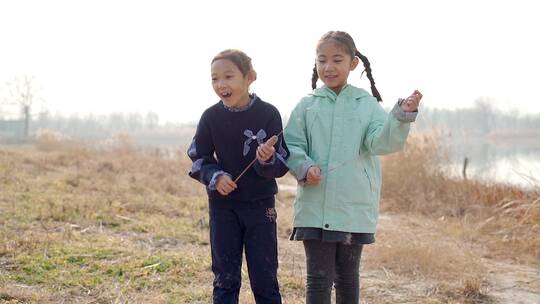 冬季在公园湖边游玩的两个中国女孩