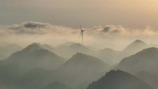 航拍大山顶上清晨云雾环绕日出风力发电风车