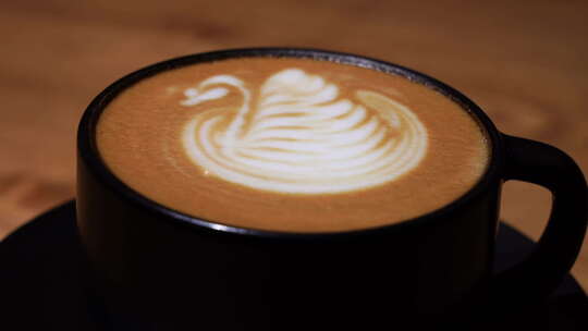 咖啡拉花艺术，天鹅图案拉花的香醇拿铁咖啡