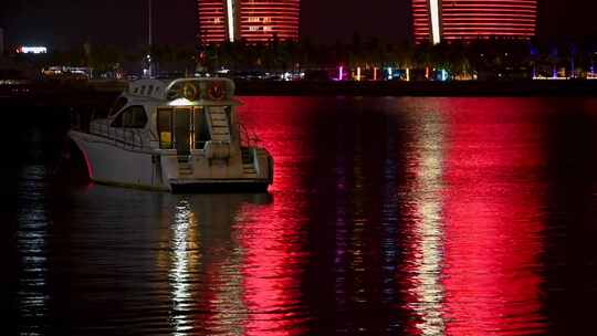 海南三亚夜晚凤凰岛海面游艇船只倒影夜景