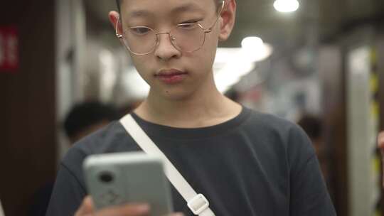 男生在地铁站看手机视频素材模板下载
