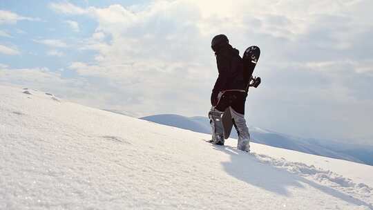 一个人拿着滑雪板在雪地里步行