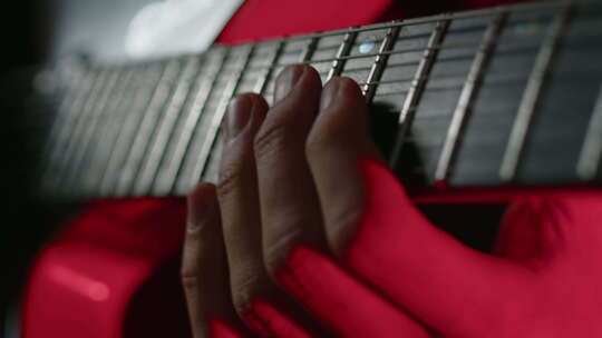 吉他手在电吉他指板上熟练移动手指的特写镜