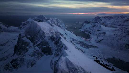 空中探索揭示了北极光下挪威的雪峰