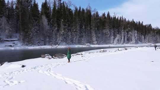 航拍新疆阿勒泰冬季喀纳斯游客在雪地上游玩