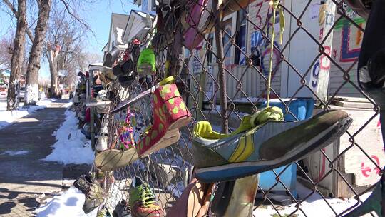鞋子挂在贫民区的栅栏上视频素材模板下载