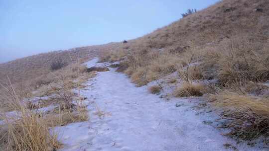 3冬天，骑山地车的人沿着当地山麓白雪覆盖