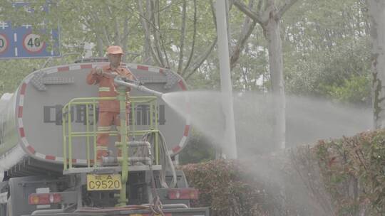 环保车清洁栏杆给植被洒水