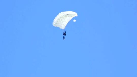 一名穿着白色降落伞的男子坠落