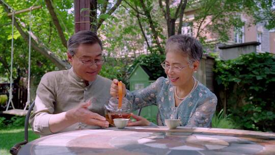 老年夫妇坐在院子里喝茶视频素材模板下载