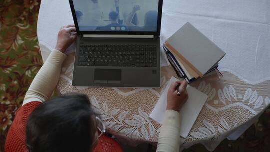 居家办公开会 看视频做笔记的女人
