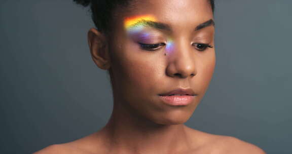 灰色背景下黑人女性脸上的自然美、激进主义和彩虹光或光线