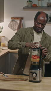 退休黑人在家用搅拌机制作维生素奶昔的垂直