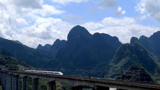 航拍山谷隧道中驶出的高铁列车