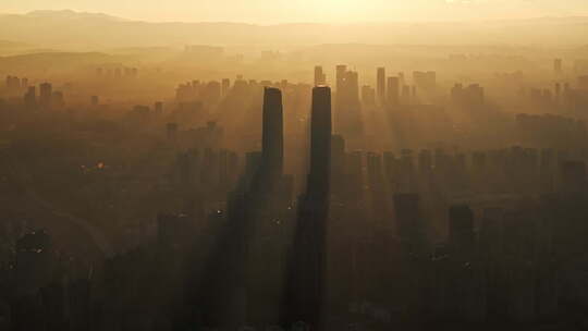 日出时金色光影中的昆明城市高楼