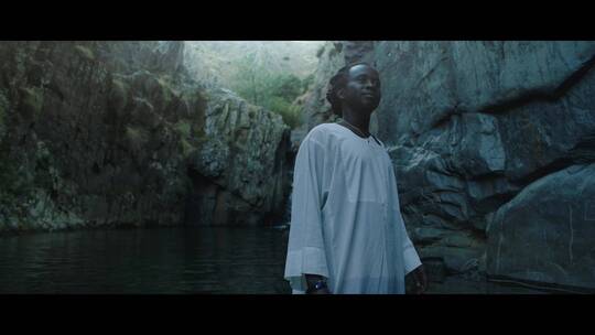 黑皮肤男人站在湖边视频素材模板下载