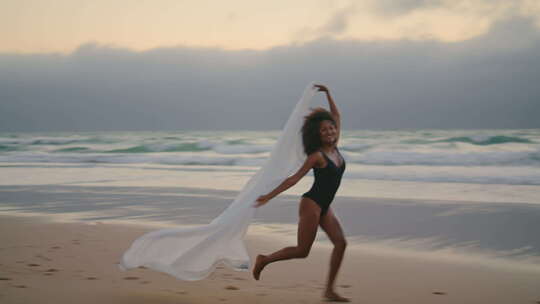 女孩跑海滩Pareo在夏日风中摇摆