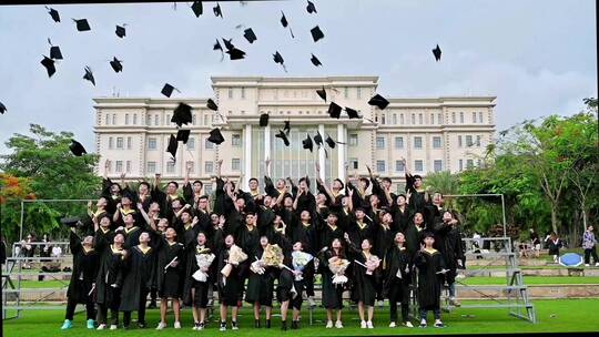 大学毕业季毕业礼服集体合照抛学士帽瞬间。