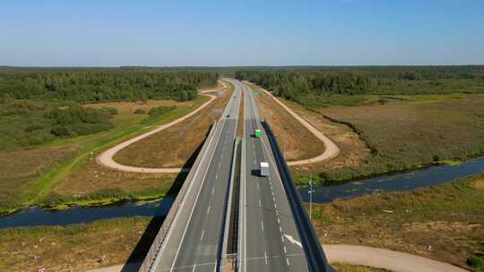 货运卡车在高速公路上行驶，穿过森林景观，