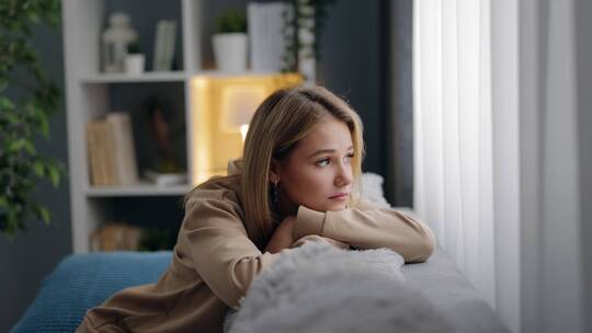 女人在沙发上看向窗外