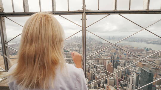 女孩站在楼顶俯视城市