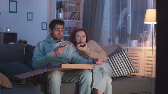夜晚一对夫妇在家里看恐怖电影视频素材模板下载