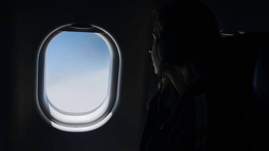 女人坐飞机望向窗外
