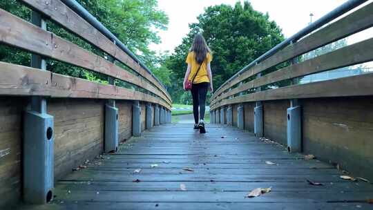 4K-雨后走在木桥上的女孩背影